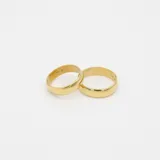 Par de alianzas de diseño bombé clásico, confeccionadas en oro amarillo 18k con acabado pulido brillante.
