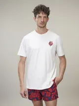 Remera de manga corta color gris jaspeado, confeccionada en algodón, con cuello redondo y estampado pequeño de corazón con flores en el pecho. Corte clásico.