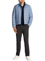 Campera acolchada Tommy Hilfiger color celeste, repelente al agua, con cuello alto, cierre de cremallera, dos bolsillos laterales con cremallera, logo de Tommy Hilfiger bordado en el pecho y diseño plegable.