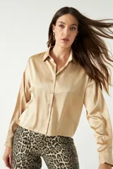 Camisa color dorado confeccionada en satén, de corte relajado y largo a la cadera.