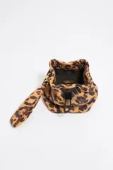 Neceser tipo bucket de nailon y piel con estampado animal print, estructura blanda y asa extraíble. Incluye cierre ajustable, bolsillo interior y placa metálica logotipada. Marca Bimba y Lola.