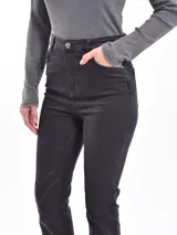 Pantalón de jean negro de tiro alto, corte recto y aberturas en el ruedo.