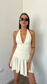 Vestido corto blanco con escote halter y falda con volados.