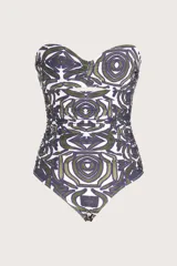Traje de baño enterizo tipo bandeau con escote strapless, diseño con pliegues horizontales en el frente y estampado geométrico orgánico en tonos verdes y púrpuras.