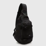 Mochila tipo bandolera de un solo hombro, color tostado, con correas ajustables negras y cierre frontal.