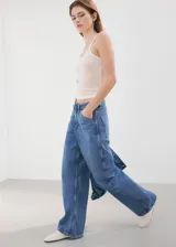 Jeans de denim de tiro medio y corte recto, con diseño clásico de cinco bolsillos y lavado azul medio.