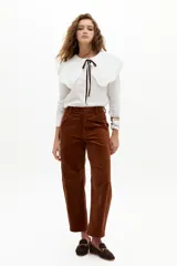 Pantalón de corduroy color caramelo, de corte barrel relajado, tiro medio, cierre frontal y bolsillos laterales y traseros.