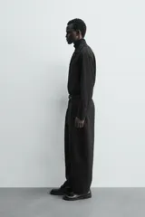 Camisa de corte relajado confeccionada en tejido mezcla de viscosa, con cuello solapa, cierre frontal de tres botones y manga larga con puños abotonados.