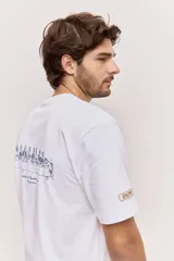 Remera blanca de algodón, de corte holgado y mangas cortas, con pequeño estampado azul en el pecho.