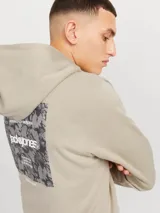 Buzo canguro beige de Jack & Jones con capucha y cordones ajustables. Estampado en la espalda con el logo de la marca y texto.