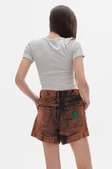 Short de denim azul oscuro con lavado acid wash, tiro medio-alto y diseño con paneles frontales marcados con costuras.