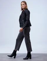 Campera de eco cuero negra, marca Baccini, con cuello con solapa y aplique de tachas. Abertura con cierre metálico cruzado, bolsillos y puños con cierre metálico y forro a tono.