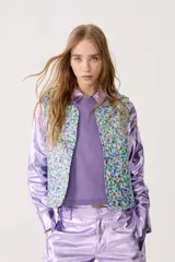 Chaleco capitoneado con estampado floral y terminación metálica.