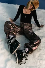 Pantalón de jean estilo oversize de tiro medio-bajo, confeccionado en denim 100% algodón. Presenta un acabado metalizado en tono peltre con efecto lavado violeta, logrando un brillo irregular y profundo. Incluye avíos metálicos personalizados y badana de PU en la parte posterior.