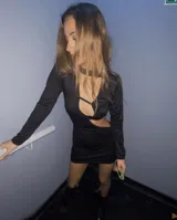 Vestido corto negro con escote asimétrico, abertura en la cintura y lazo lateral. Incluye chaqueta corta con mangas largas.