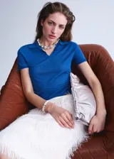 Buzo de punto color azul, con cuello polo y manga corta, de diseño recto.