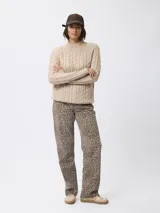 Sweater de tejido grueso con textura trenzada, cuello alto y mangas largas.