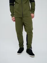 Pantalón jogger Umbro color verde militar, con detalles en negro en los laterales de las piernas y puños elásticos en los tobillos.