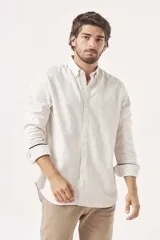 Camisa de lino color verde claro, de corte recto, con cuello abotonado y mangas largas.