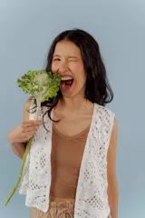 Chaleco negro de tejido de punto abierto, sin mangas y sin cierre, con cuello solapa.