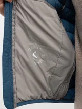 Chaleco acolchado de hombre confeccionado en nylon reciclado, con cierre frontal de cremallera, sisas elásticas y bolsillos laterales con cierre.