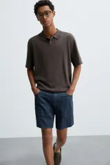 Polo de punto de corte regular fit, confeccionado en una mezcla de algodón y lyocell. Presenta cuello de solapa con cierre frontal de botones, manga corta y acabados en rib en puños y bajo.