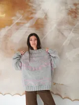 Sweater de lana gris con diseño de líneas y formas geométricas en color rosa.
