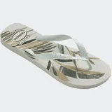 Ojotas Havaianas modelo Aloha con estampado de hojas de palmera en tonos beige, marrón y negro, sobre base blanca. Tiras blancas con textura.