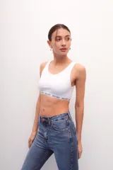 Top corto de morley color blanco, con escote redondo y elástico personalizado con el nombre de la marca en el bajo busto.