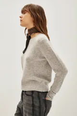 Sweater de punto color negro, con cuello redondo y mangas largas con puños acanalados.