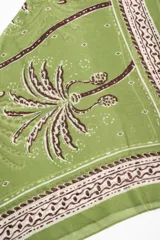 Bandana de viscosa color verde con estampado de palmeras y detalles ornamentales en tonos blancos y marrones.