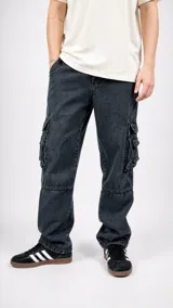 Pantalón cargo de denim en color negro con efecto lavado, corte holgado y bolsillos laterales con solapa.