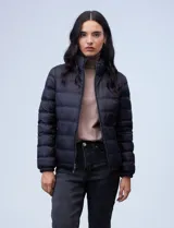 Campera de plumas reversible marca Michael Kors. Un lado es liso y el otro estampado con el logo de la marca. Tiene abertura central con cierre metálico, bolsillos delanteros y avíos metálicos con el logo. Incluye bolsa autoportante.
