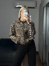 Campera bomber de gamuza con textura de corderoy, con estampado animal print de leopardo, cuello camisero, cierre frontal completo y bolsillos delanteros.