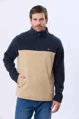 Buzo polar bicolor de hombre, con diseño en negro en la parte superior y gris en la inferior. Cuenta con cuello alto, cierre frontal medio y bolsillos laterales con cierre.
