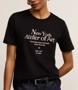 Remera negra de algodón con cuello redondo y mangas cortas. Estampa frontal con texto "New York Atelier of Art".