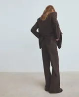 Pantalón de vestir marrón con sutil estampado a cuadros, de corte recto y tiro medio con raya central marcada.