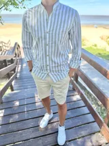 Camisa de manga larga con cuello mao, a rayas verticales en color verde y blanco, con botones frontales.