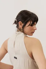 Vestido largo marrón, sin mangas, con cuello halter y bolsillos laterales.