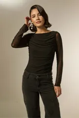 Body de manga larga con diseño al cuerpo, confeccionado en tela con textura suave y detalles de frunces en el frente. Presenta un elegante cuello bote y cierre inferior con broches.