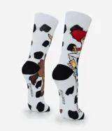 Par de medias de caña larga, blancas con estampado de vaca (manchas negras), con imágenes de los personajes Jessie y Bullseye de Toy Story. Tienen puntera y talón negros.