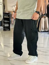 Pantalón cargo super baggy de jean color beige, de corte ancho con bolsillos laterales tipo cargo en las piernas y costuras reforzadas.