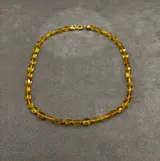 Collar de piedras semipreciosas facetadas en tono ámbar, con cierre metálico con baño de oro 18k.