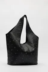 Bolso tipo tote negro de cuero sintético con micro tachas metálicas plateadas. Tiene asas integradas para llevar al hombro.