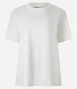 Remera de corte boxy con cuello redondo y mangas cortas. Confeccionada en algodón, presenta un diseño minimalista sin estampas con sisa caída.