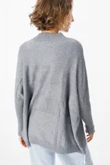 Sweater crudo de punto con cuello alto y mangas largas con puños ajustados.