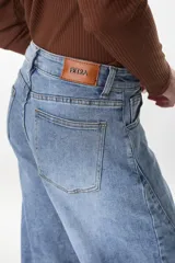 Jean de denim celeste con silueta amplia y tiro medio, de corte recto y holgado. Cuenta con bolsillos traseros clásicos y etiqueta de marca en la parte posterior de la cintura.