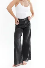 Pantalón de jean negro con costuras blancas y corte amplio.