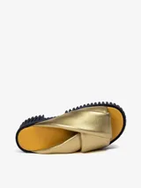 Sandalias doradas con plataforma negra y base amarilla. Tiras anchas y acolchadas de piel de oveja.