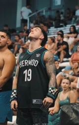 Musculosa de básquet negra con detalles en turquesa, con nombre "Hermod" y número "19" estampados en blanco.